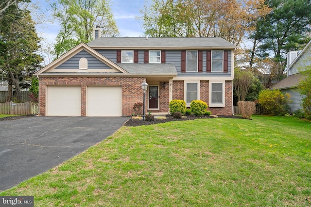 traditional home with a front lawn, an attached garage, aphalt driveway, brick siding, and fence