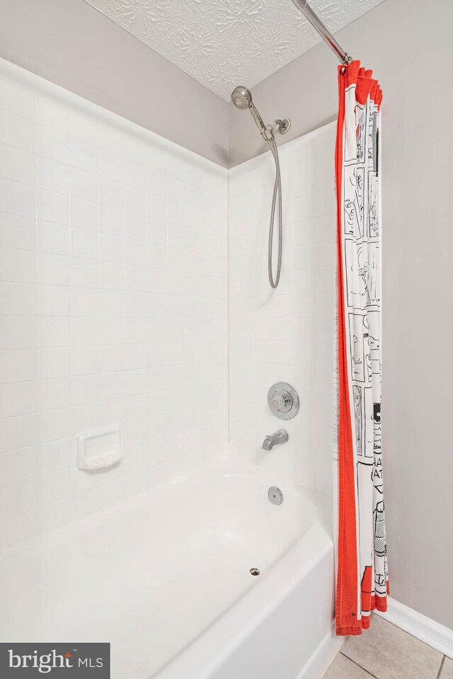 full bath featuring tile patterned floors, shower / tub combo with curtain, and a textured ceiling