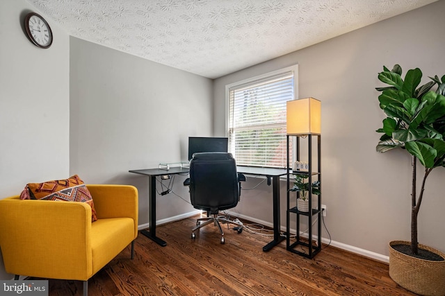 office area with a textured ceiling, wood finished floors, and baseboards