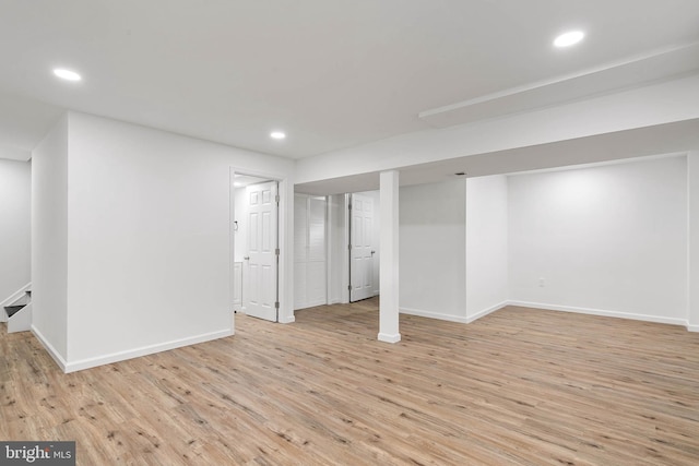 finished basement with recessed lighting, light wood-type flooring, and baseboards