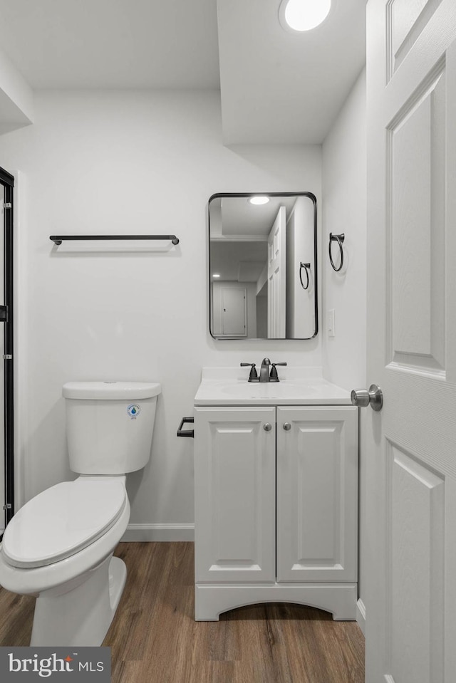 bathroom with vanity, baseboards, toilet, and wood finished floors