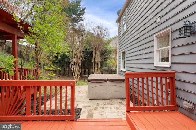 wooden terrace with a patio area, fence, and a hot tub