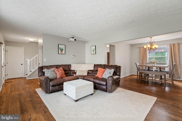 living area featuring dark wood-style flooring, a chandelier, and a textured ceiling