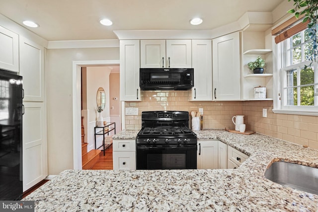 kitchen with white cabinets, light stone countertops, black appliances, and open shelves