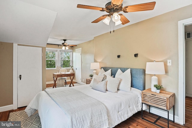 bedroom with baseboards, ceiling fan, wood finished floors, and visible vents
