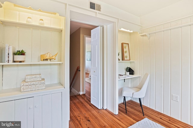 hall with wood finished floors and visible vents