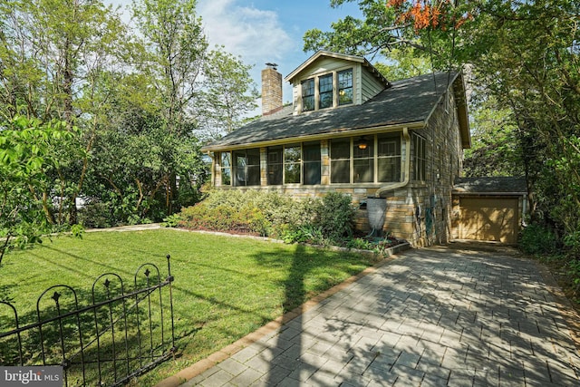 exterior space with driveway, a chimney, a lawn, a sunroom, and a garage