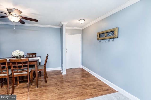 dining room with baseboards, a ceiling fan, ornamental molding, and wood finished floors