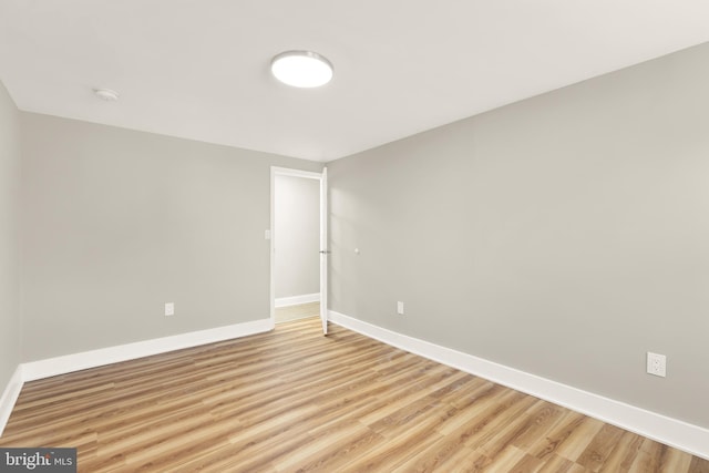 spare room with light wood finished floors and baseboards