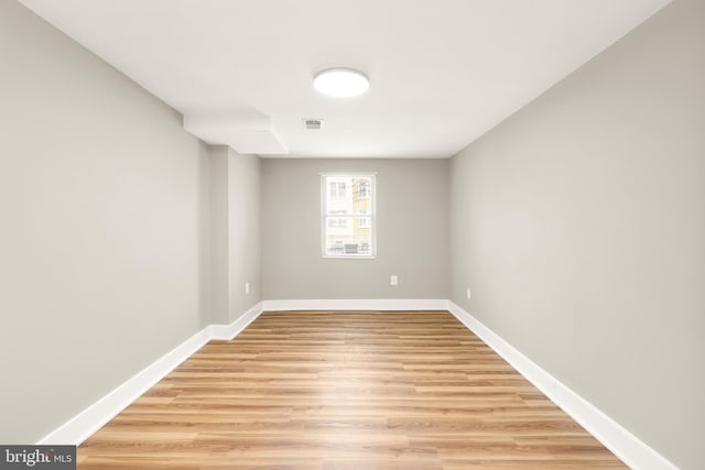 empty room featuring visible vents, baseboards, and light wood finished floors