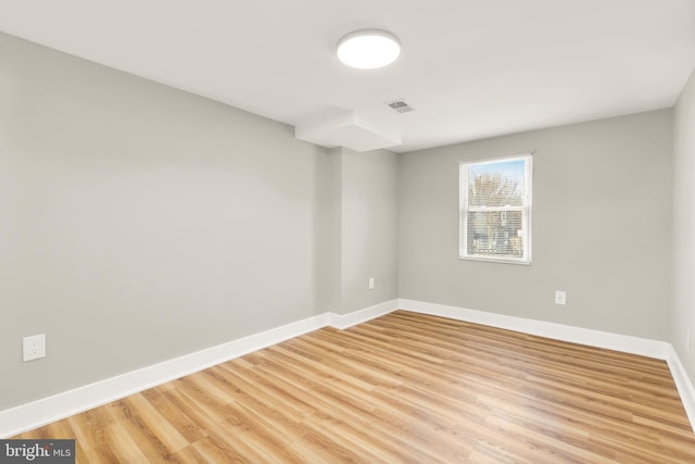 empty room with visible vents, baseboards, and light wood-type flooring