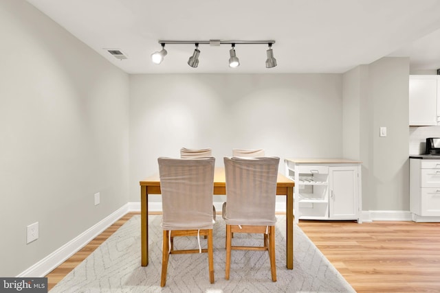 dining room featuring light wood-type flooring, baseboards, and visible vents