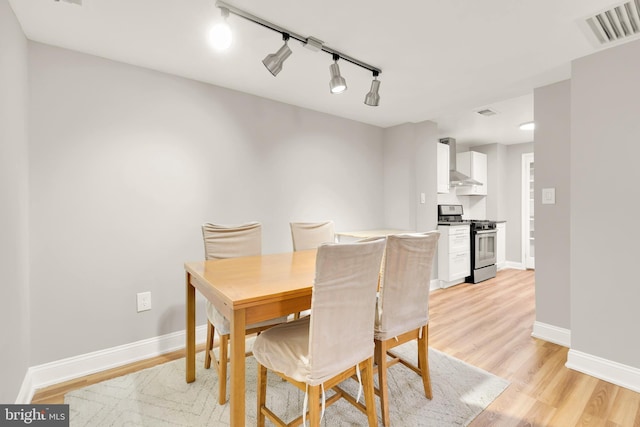 dining space with visible vents, baseboards, and light wood finished floors