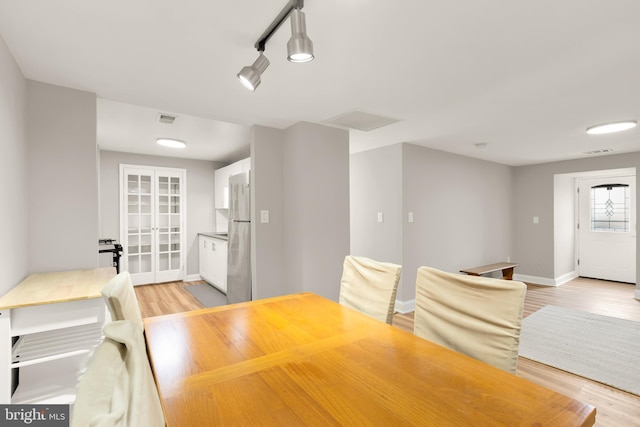 dining area featuring visible vents, baseboards, and light wood-style floors