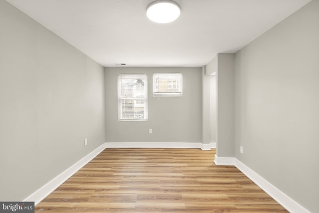 unfurnished room featuring visible vents, light wood-style flooring, and baseboards