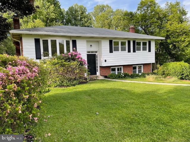 3433 Gregg Rd, Brookeville, MD 20833 - bi-level home featuring a chimney, a front lawn, view of scattered trees, and brick siding
