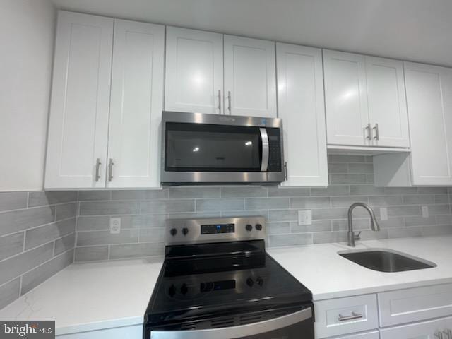 3433 Gregg Rd, Brookeville, MD 20833 - kitchen featuring stainless steel microwave, range with electric cooktop, a sink, white cabinets, and light countertops