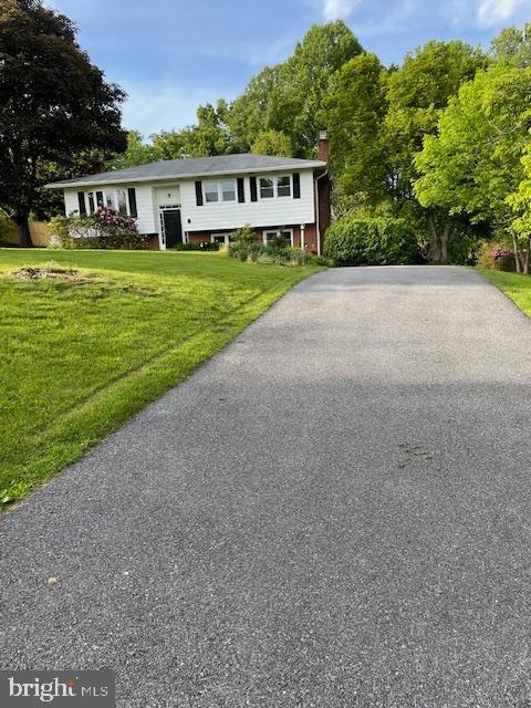 3433 Gregg Rd, Brookeville, MD 20833 - split foyer home with a chimney, a front lawn, and asphalt driveway