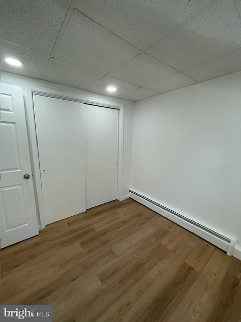 3433 Gregg Rd, Brookeville, MD 20833 - unfurnished bedroom featuring baseboard heating, wood finished floors, a paneled ceiling, a closet, and recessed lighting
