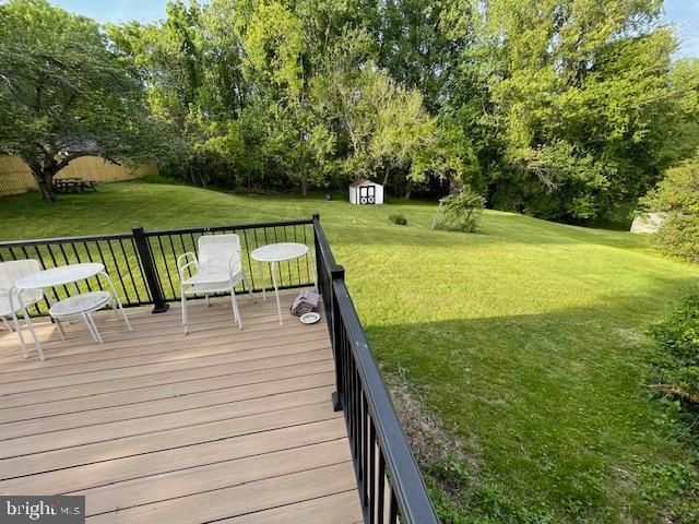 3433 Gregg Rd, Brookeville, MD 20833 - wooden deck with a storage shed, a yard, an outdoor structure, and view of scattered trees