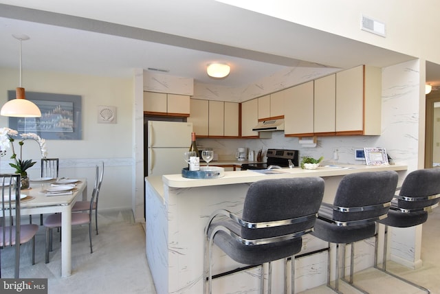 108 120th St Unit 5462, Ocean City, MD 21842 - kitchen with under cabinet range hood, stainless steel electric range oven, visible vents, freestanding refrigerator, and a peninsula