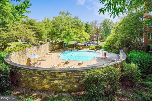 community pool with fence and a patio