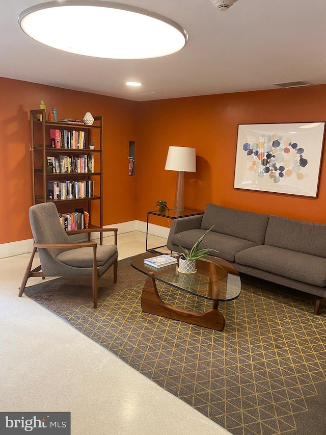 living area with baseboards and visible vents
