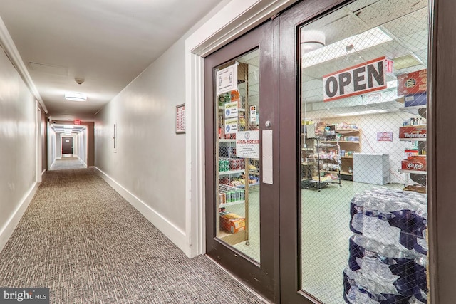 hallway featuring carpet floors and baseboards