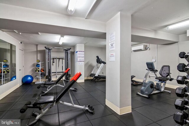 exercise room featuring baseboards and a wall unit AC