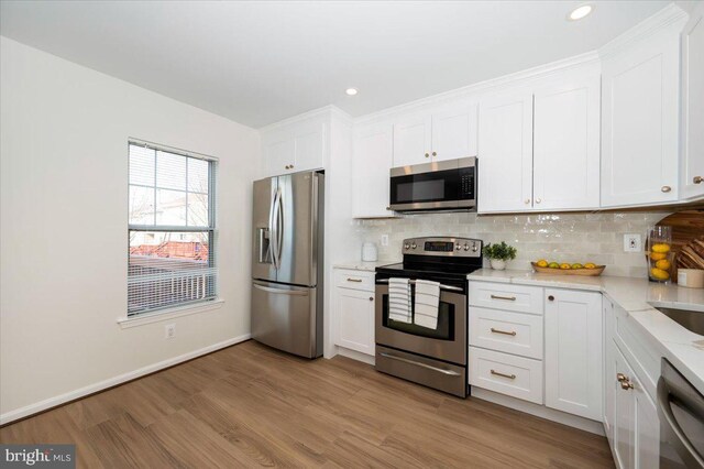 kitchen with white cabinets, light wood-style floors, and appliances with stainless steel finishes