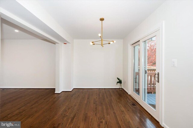 unfurnished dining area with an inviting chandelier, baseboards, and wood finished floors