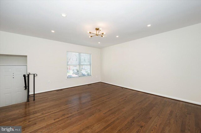 spare room with baseboards, a chandelier, recessed lighting, and dark wood finished floors
