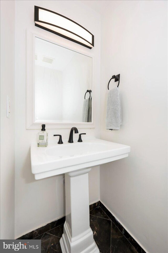 bathroom with baseboards and marble finish floor