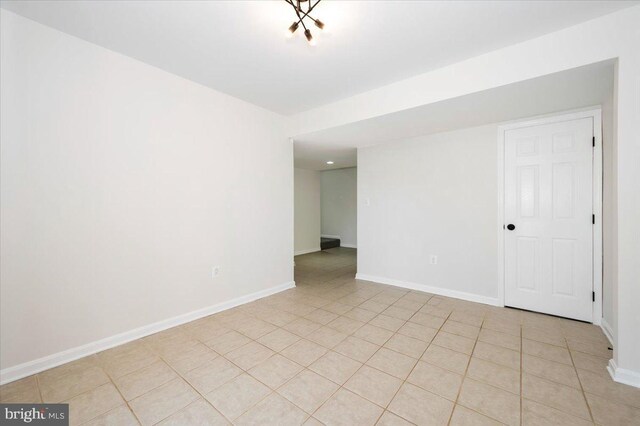 empty room with baseboards and light tile patterned floors