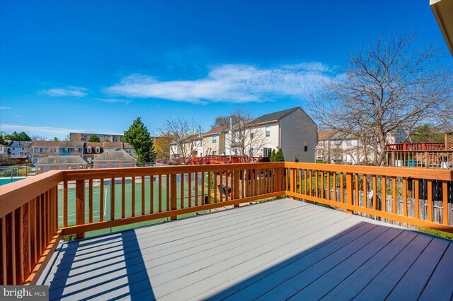 wooden terrace featuring a residential view and a lawn