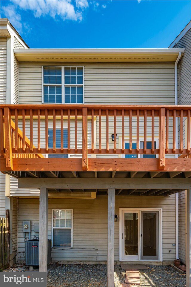 back of property with central AC unit and a deck