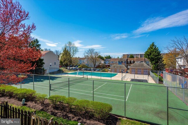 view of sport court with fence and a residential view