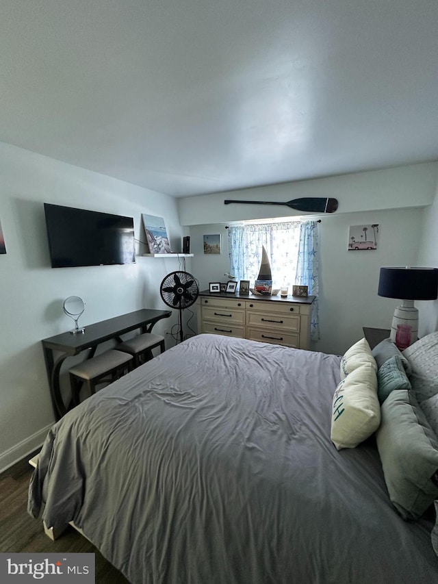 bedroom featuring baseboards and wood finished floors