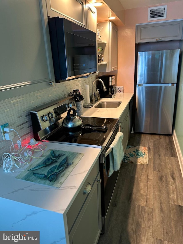 kitchen with visible vents, a sink, black microwave, range with electric stovetop, and freestanding refrigerator