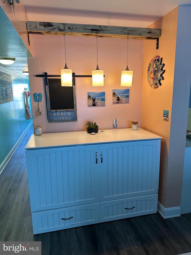bar featuring baseboards, decorative light fixtures, and dark wood-style flooring