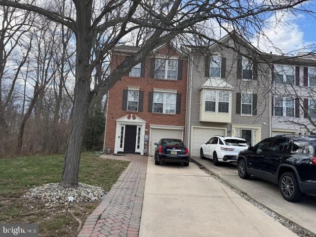 view of front of home featuring brick siding, a garage, and driveway