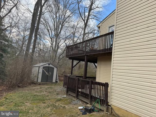 view of yard with a storage shed, an outbuilding, and a wooden deck