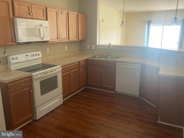 kitchen with dark wood-style floors, light countertops, a sink, and white appliances