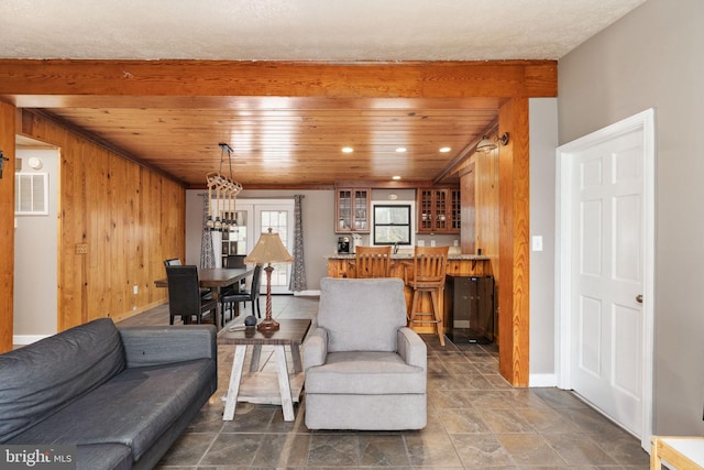 living room with baseboards, recessed lighting, wood walls, visible vents, and wood ceiling
