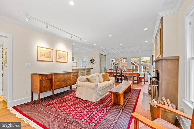 living room featuring wood finished floors, baseboards, ornamental molding, and recessed lighting