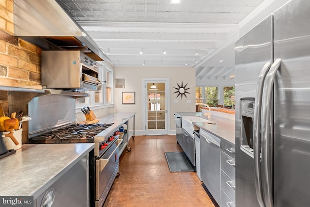 kitchen featuring baseboards, gray cabinets, light countertops, stainless steel appliances, and a sink