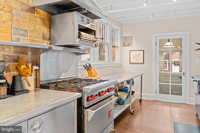 kitchen with range hood, stainless steel stove, baseboards, and rail lighting