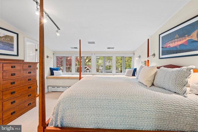 carpeted bedroom with track lighting, a baseboard heating unit, and visible vents