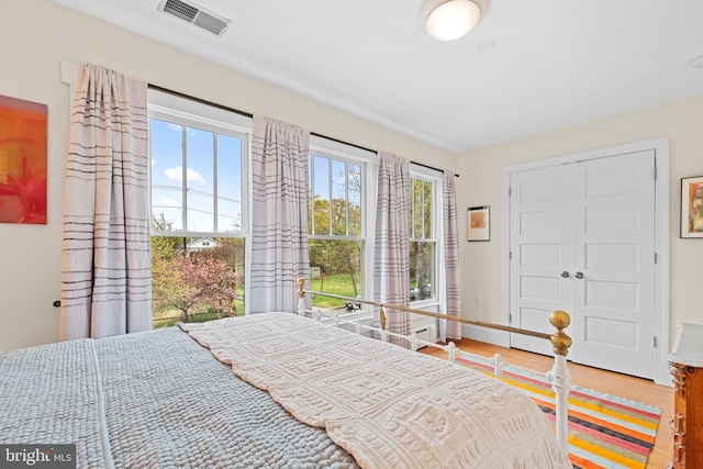 bedroom featuring visible vents and wood finished floors