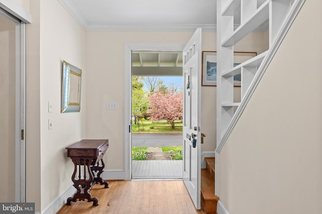 foyer featuring ornamental molding, baseboards, and hardwood / wood-style flooring